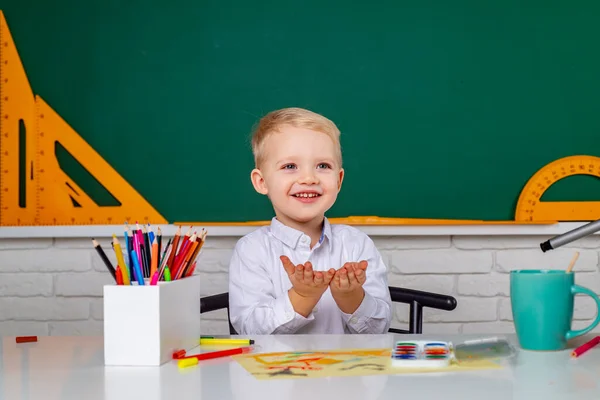 Ungarna gör sig redo för skolan. Ett vänligt barn i klassrummet nära skrivbordet. Individuell undervisning. — Stockfoto