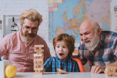 Üç nesildir erkekler birlikte eğleniyor. Büyükbaba torununa Jenga oynamayı öğretiyor..
