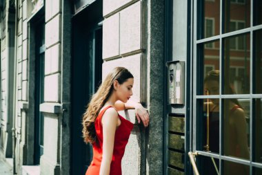 Şehir merkezinde poz veren muhteşem lüks bir kadının açık hava hayat portresi. Neşeli, mutlu, güzel bir genç kız. Genç, çekici, neşeli kadın şehirde yürüyor..