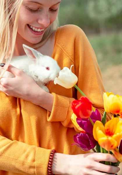 Портрет молодой женщины, позирующей с кроликом. Прекрасная женщина держит белого кролика . — стоковое фото