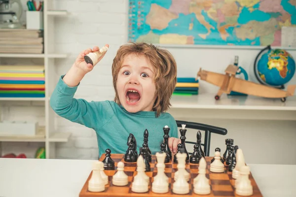 Chess school. Son are playing chess and smiling at home. Little clever boy thinking about chess. — Stock Photo, Image