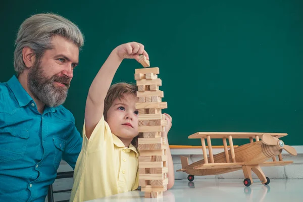 Otec a syn hrají hry Jenga. Ruční řízení pohybu Building Computational Skills. Koncept dětské hry. — Stock fotografie