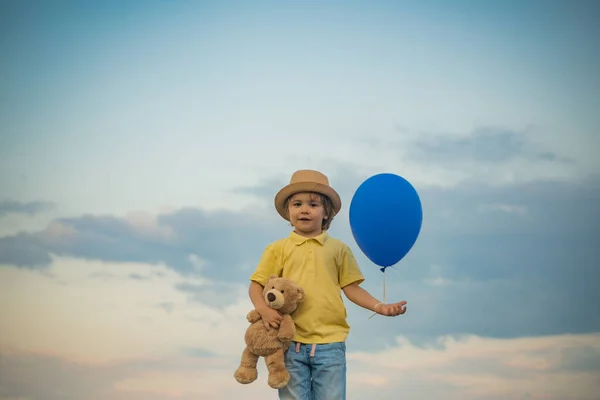 The cute boy in the nature on sunset sky. Concept for safety and child development. Childhood on countryside. Childhood memories. — Stock Photo, Image