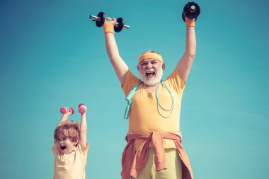 Her gün egzersiz yapıyoruz. Spor gibi. Çocuklar için spor egzersizi. Yaşlı olgun bir adam ve küçük bir çocuk halterle egzersiz yapıyor. Büyükbaba ve çocuk sabah egzersizi yapıyorlar. Çocuklar için spor.