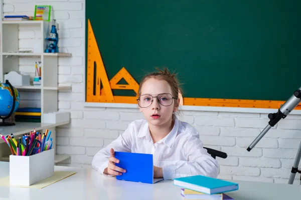 Criança perto de quadro-negro na sala de aula da escola. Miúdos da escola. Menina da escola primária na escola . — Fotografia de Stock