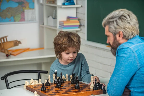 Otec učí syna hrát šachy. Den otců. Vzdělávání a učení lidé koncept - žák a učitel. Otec a syn. — Stock fotografie