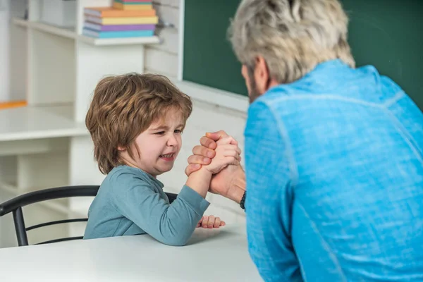 Father and son during friendly arm wrestling competitionat home. The father and son holding hands. Father and son compete in arm wrestling. — Stock Photo, Image