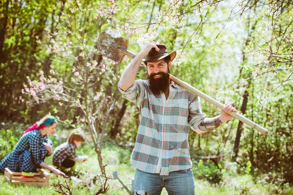 Mensch Bauer. Glückliche Familie im Garten. Paar mit Bauernkind pflanzt Sprossen im Garten. — Stockfoto