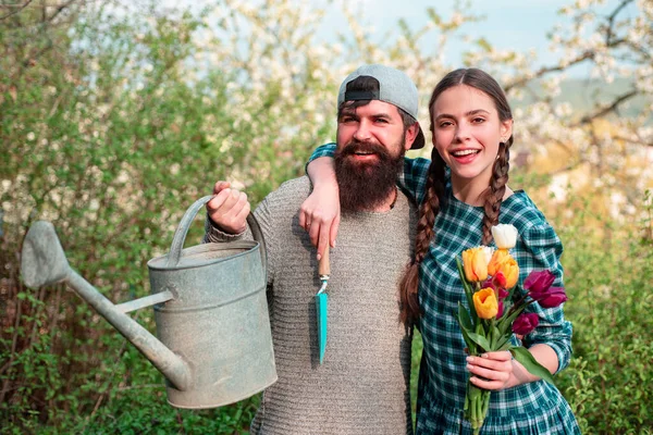 Смішна пара садівника, що тримає садові інструменти на весняному фоні природи. Друзі рослини і рослини. Прекрасний весняний день . — стокове фото