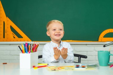 İlkokul öğrencisi portresi kapalı alanda çalışıyor. Çocuk bilimi eğitimi konsepti. İlkokuldan çocuklar. Çalışmaya biraz hazır..