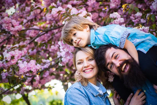 Mother father and son hugging in the spring park. Family outdoors. Happy family.