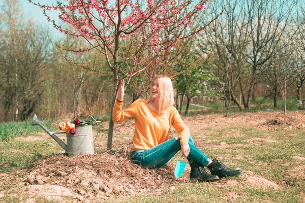 Giardiniere ragazza giardinaggio sul giardino primaverile. La gente fa giardinaggio. Felice giardiniere donna con annaffiatoio può . — Foto Stock