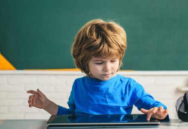 Okul sınıfında dijital tabletli bir öğrenci. Çocuk Bilimi Eğitim Konsepti.