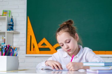 İlkokul ve eğitim. Okula dönelim. İlkokul sınıfı. Sınıfta, tahtaya yakın arkadaş canlısı bir çocuk. Yetenekli çocuk.