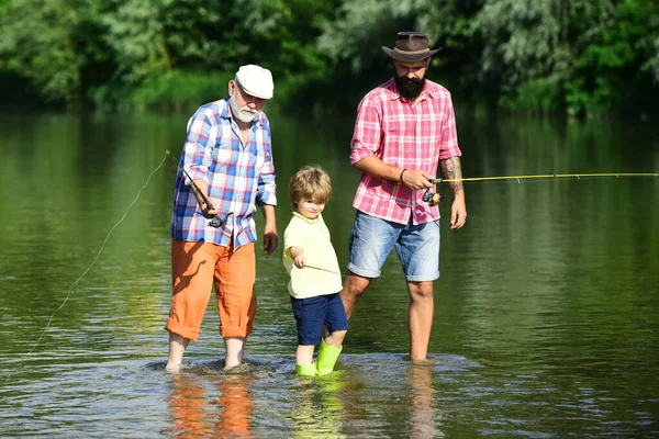 Pesca. Ragazzino pesca a mosca nel fiume con il padre e il nonno . — Foto Stock