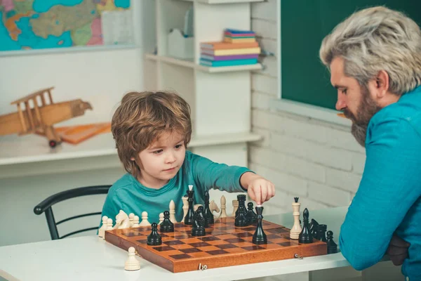 Père enseignant fils. Professeur et enfant. Parentalité. Retour à l'école et concept d'éducation. Garçon penser ou planifier sur le jeu d'échecs - style pour le concept de l'éducation . — Photo