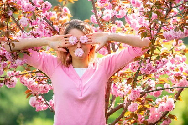 Funny girls with blooming sakura cherry Flover. Closing eyes with flovers. Hides eyes. 8 march womens day. — Stock Photo, Image