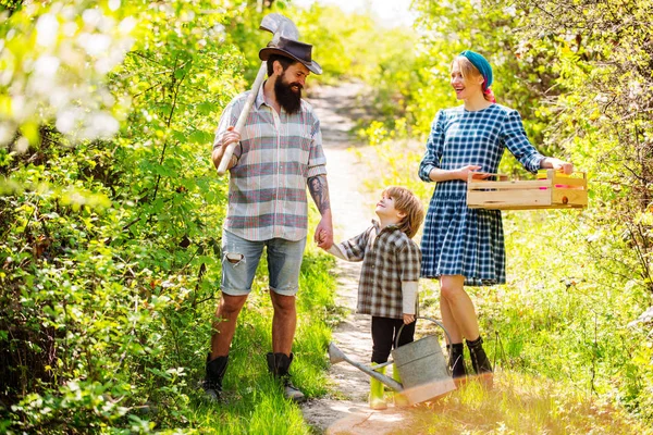 Famiglia felice in giardino. Moglie e marito con figlio piantare nell'orto. Una coppia con figlio di fattorie che lavorano in giardino. Eco vita . — Foto Stock