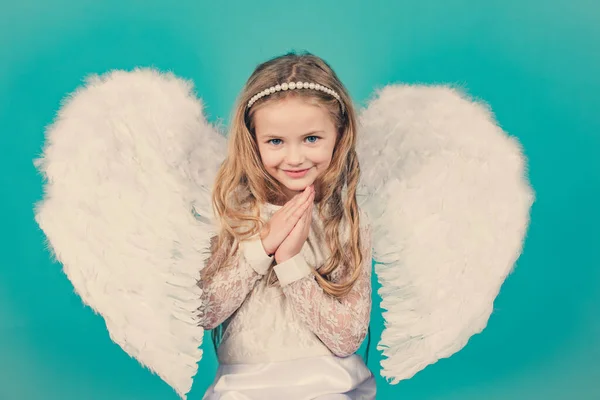 Os anjos cruzaram as mãos por ti. Mischievous pequena menina anjo de pé com seus punhos apertados . — Fotografia de Stock