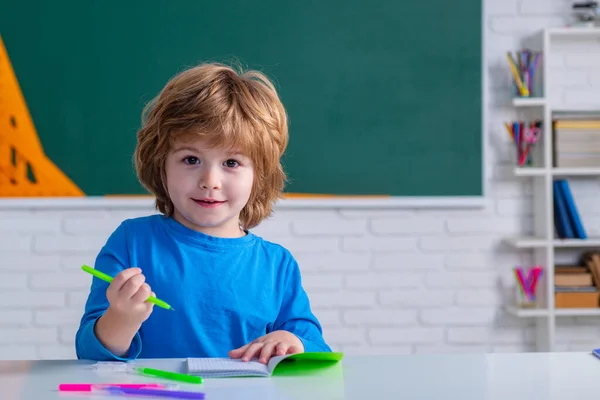 Alumno de primaria. Niños aprendiendo. Niño lindo en el aula cerca del escritorio de pizarra. Espacio de copia pizarra . —  Fotos de Stock