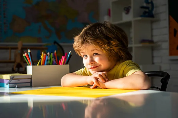 Alunno carino con divertente lavoro di scolarizzazione del viso. Carino bambino in età prescolare con insegnante che studia in classe. Processo educativo . — Foto Stock