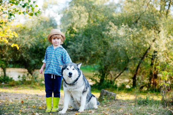 Crianças com um cão caminhando ao longo da natureza. As crianças envelhecem. Miúdos na aldeia. Conceito de crianças ativas . — Fotografia de Stock