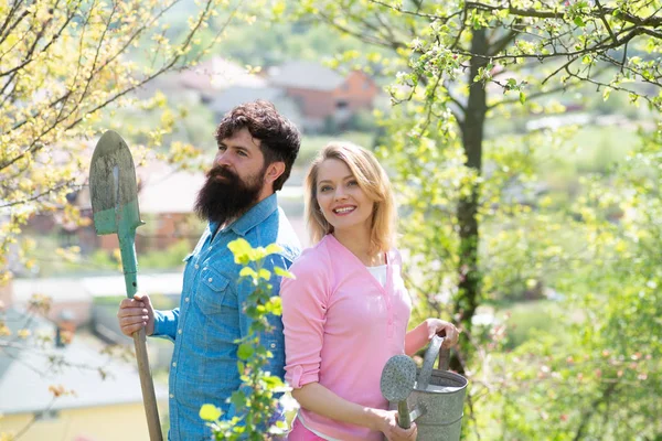 Ehepaar Gärtner. Werden Sie Biobauer. Frau und Mann verbringen Zeit im Obstgarten. Porträt eines jungen glücklichen Paares im Hof während des Frühlings. — Stockfoto