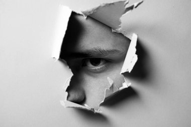 Adam kağıda bakıyor. Kıskanç bir koca. Çocuğun gözüyle kağıtta yırtılmış bir delik. Beyaz kağıttaki delikten bakan adamın portresi. Güvenilmez bir bakış. Casus gözü. Meraklı ve dedikoducu..