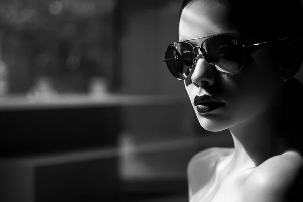 Female fashion model posing with sunglasses. Sexy. Close-up portrait of a beautiful charming young attractive woman in a sunglasses. Portrait of serious desire woman. Beauty trends. Dark background. — Stock Photo, Image