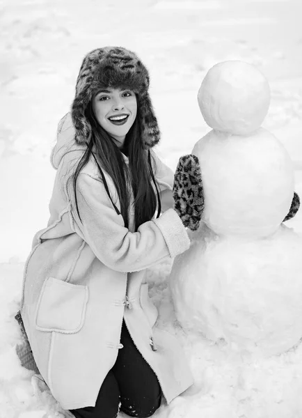 Chica divertida de Santa posando en el clima invernal. Chica jugando con muñeco de nieve en el parque de invierno. Feliz Navidad y Felices Fiestas. Hacer muñeco de nieve y diversión de invierno para niña . — Foto de Stock