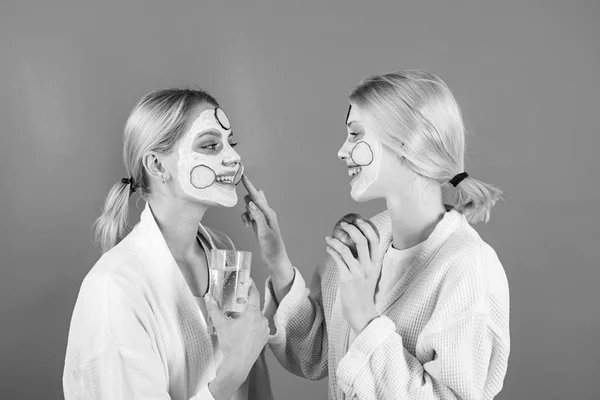 Femme appliquant de la crème pour la peau. Portrait de deux beaux jeunes modèles féminins avec maquillage naturel du visage. Crème visage. Belle jeune femme visage avec peau fraîche . — Photo