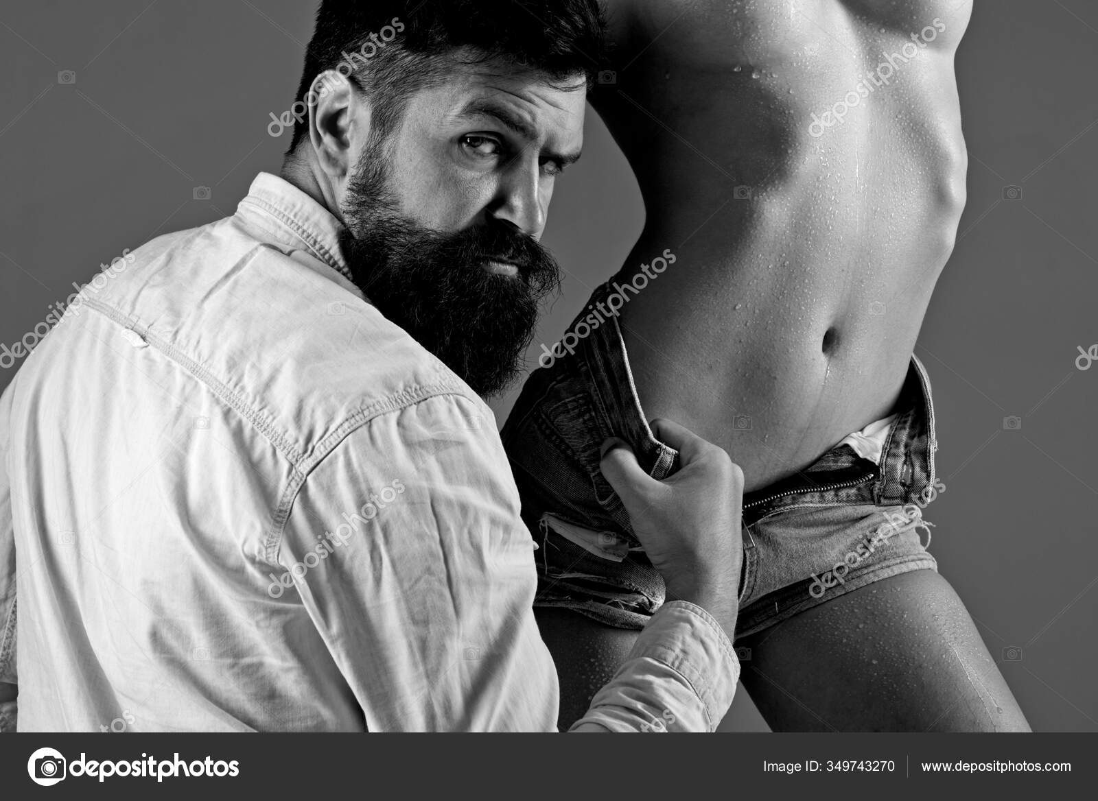 Stylish bearded man. Handsome man with nacked woman on gray background. Portrait of sexy Brutal man with Sexy curves girl butt. Sensual girl. Men denim