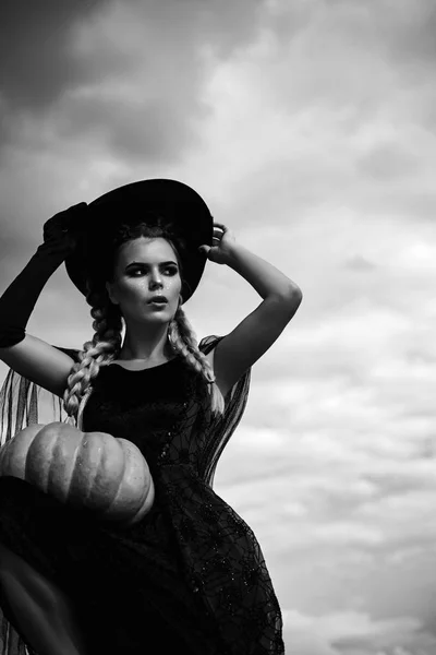Fel és félelmetes koncepció nő. Ünnepe párt. Gyönyörű fiatal meglepett nő boszorkány kalap és tök gazdaság jelmez. — Stock Fotó