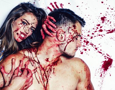 Blood is flowing down the neck, bite marks are visible. Sexy woman vampire bites a mans neck. Woman with red blood and with blond hair. Killer, maniac. Desire, thirst concept.
