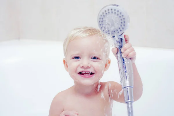 Мила дитина миє волосся у ванні. Концепція охорони здоров'я та повсякденного життя. Дитина з рушником після прийняття ванни. Дитяча ванна . — стокове фото