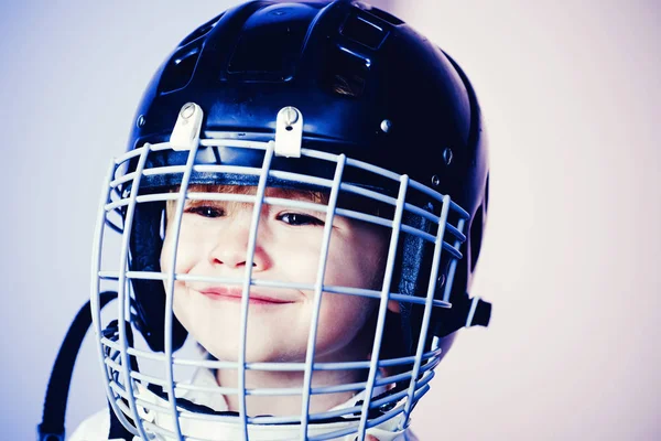 Safety and protection. Protective grid on face. Sport equipment. Hockey or rugby helmet. Sport childhood. Future sport star. Sport upbringing and career. Boy cute child wear hockey helmet close up