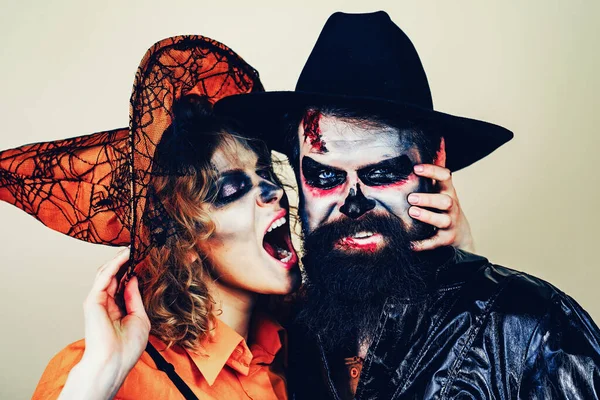 Una coppia di Halloween. Giovani donne strega in cappello di Halloween e uomo barbuto su sfondo isolato . — Foto Stock