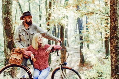 Mükemmel sonbahar tarihi için fikirler. Bisikletile romantik bir tarih. Sakallı adam ve kadın sonbahar ormanında dinleniyor. Romantik bir çift. Tarih ve aşk. Aşık çift orman parkında birlikte bisiklete biniyor