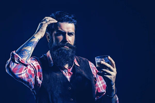 Retro vinař s whisky nebo skotskou. Ochutnávka a degustace. Barman s vousy drží skleněnou brandy. Koncept luxusních nápojů. — Stock fotografie