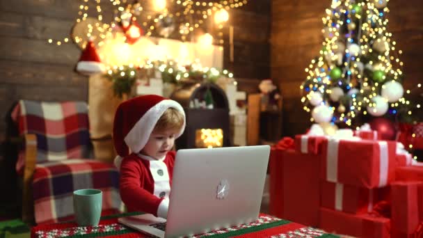 Crianças bonitos com laptop no fundo de Natal em casa. Feliz Natal e Feliz Ano Novo para a criança. Presentes de Natal na sala de estar em casa . — Vídeo de Stock