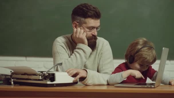 Pai e filho digitando na velha máquina de escrever e laptop. Velhos e jovens. Progresso tecnológico . — Vídeo de Stock