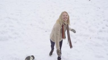 Kadın kartopu savaşı oynarken eğleniyor. Kız kartopu atıyor. Kış eğlencesi. Tatlı kız kartopu savaşı..