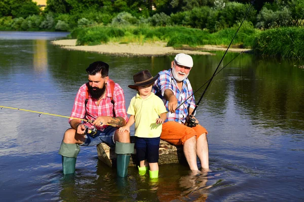 Grandfather and father with cute child boy are fishing. Fishing. Happy weekend concept. Outdoors active lifestyle.