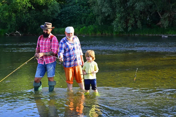 父亲教他的儿子如何从河流和风景的角度钓鱼。户外积极的生活方式。祖父和孙女。周末快乐的概念. — 图库照片