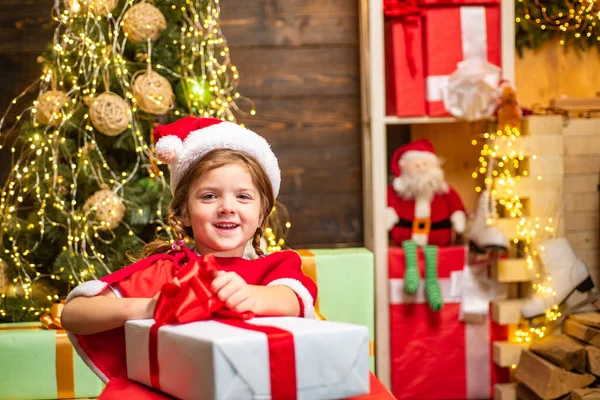 Σπίτι Χριστουγεννιάτικη ατμόσφαιρα. Χαριτωμένα παιδάκια που γιορτάζουν Χριστούγεννα. Ευτυχισμένο παιδί που διασκεδάζει με το δώρο. Χριστουγεννιάτικα παιδιά. — Φωτογραφία Αρχείου