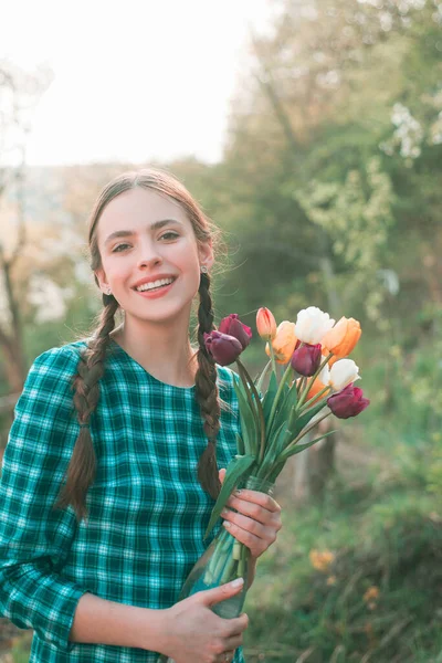 Счастливая красавица держит тюльпаны в саду . — стоковое фото