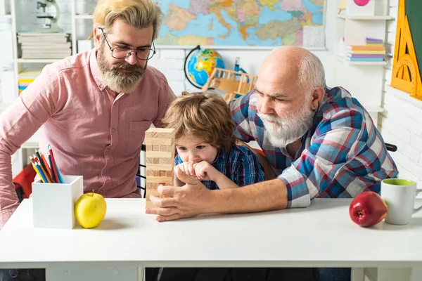 Parenting infanzia valori week-end. Felice tre generazioni di uomini che giocano a Jenga in classe . — Foto Stock