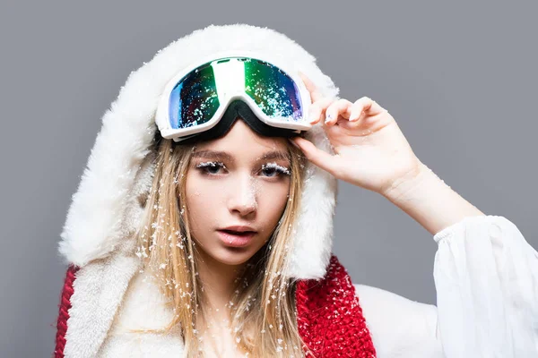 まつ毛の上の雪片。安全メガネのスノーボード女子。冬だ。スポーティなマスクを身に着けてかわいい笑顔のスキーヤーの女の子のクローズアップ肖像画。若い熱心なスポーツ女性。隔離されてる。幸せな冬の休日. — ストック写真