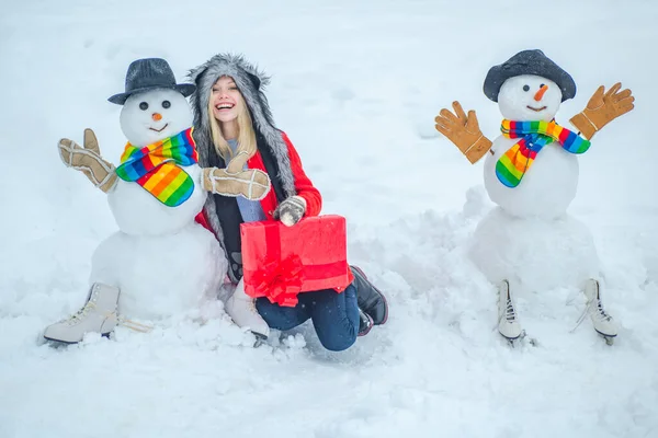 Les gens aiment l'hiver. Bonhommes de neige mignons avec fille d'hiver debout dans le paysage de Noël d'hiver. Happy girl portrait d'hiver . — Photo