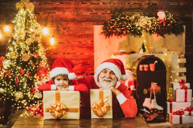 Hediyeleriyle komik küçük Noel Baba yardımcısı. Hediye dolu çanta taşıyan Noel Baba yardımcısı. Noel Baba 'yla tanışmak istiyorum. Noel çocuk Noel 'i evde kutluyor..